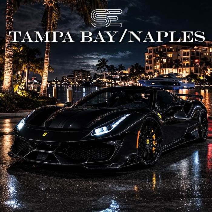 Sleek black sports car parked by a waterfront at night, with illuminated buildings and palm trees in the background. Text reads "Tampa Bay/Naples".