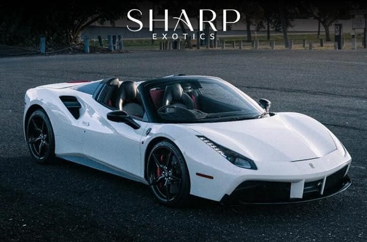 White convertible sports car parked in an open area, with "Sharp Exotics" text above.