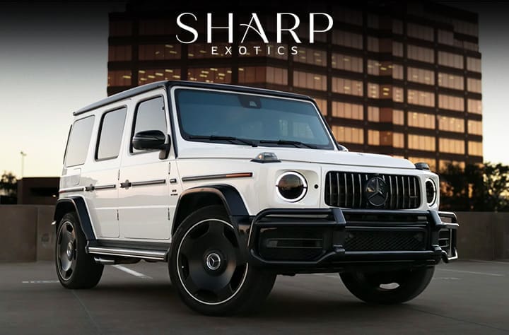 White luxury SUV parked in front of a modern building, with "Sharp Exotics" text above.