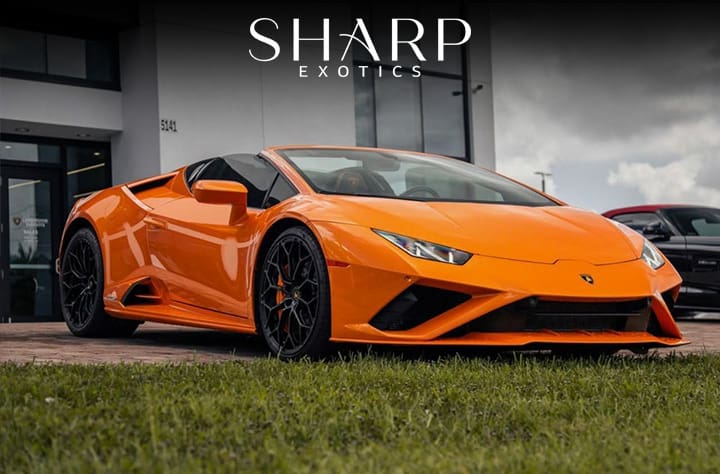 Orange convertible sports car parked on a driveway, with "Sharp Exotics" logo above. Building and grassy area in the background.